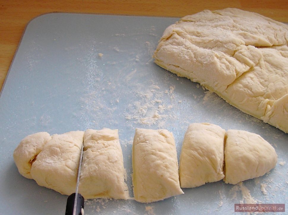 Knead the dough, cut it in small pieces. Place dough pieces on slightly floured surface and roll each piece into a thin circle.