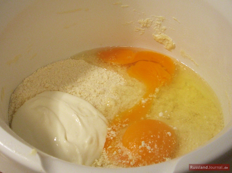 Яйца, мука и сметана в миске: тесто для пирога с клюквой
