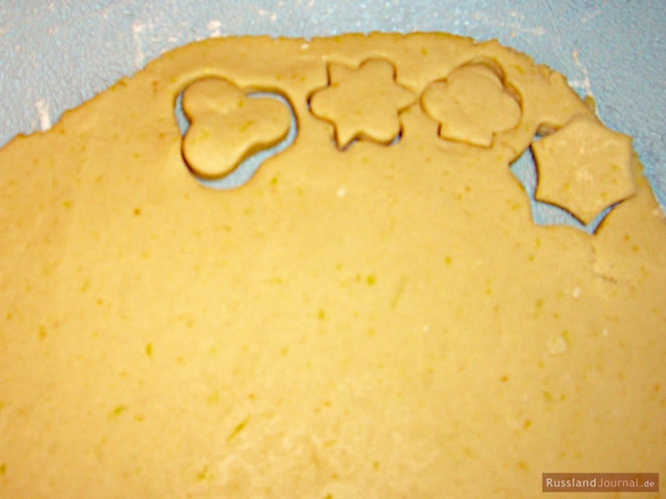Раскатанное тесто с 4 вырезанными формами для песочного печенья