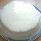 Облитый белым кремом круглый торт Липун