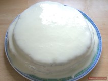 Облитый белым кремом круглый торт Липун