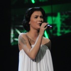 Анастасия Приходько поёт на сцене в длинном белом платье