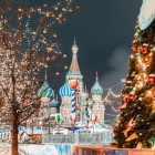 Roter Platz in Moskau mit Silvester und Weihnachtsdekoration. Blick auf die Basilius-Kathedrale, geschmückter Tannenbaum, Bäume mit roten und goldenen Kugeln.