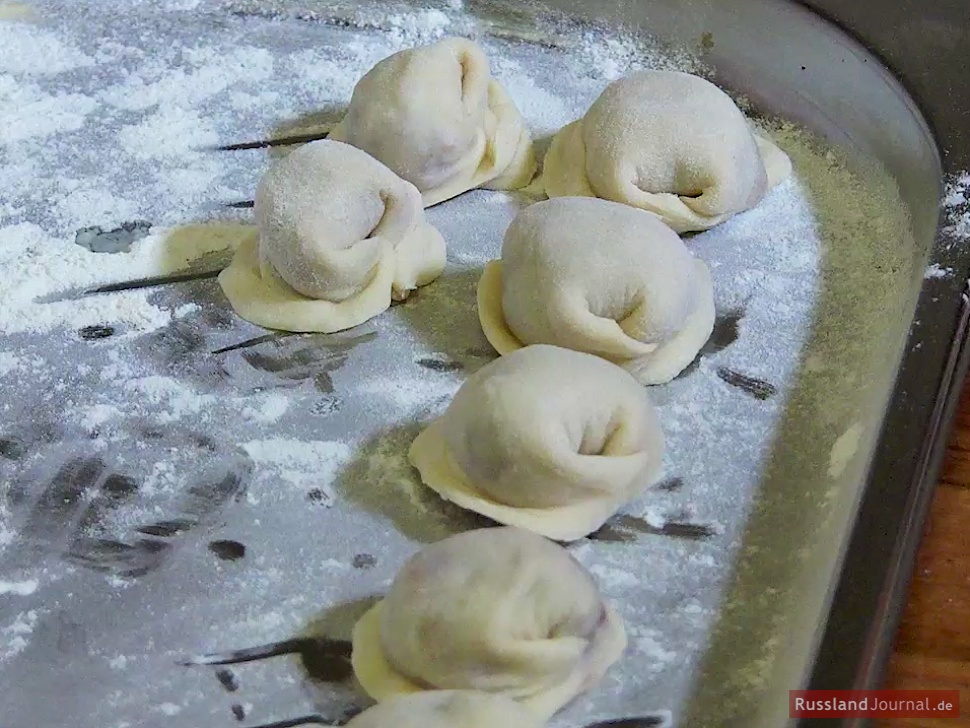 Sibirische Pelmeni auf einer bemehlten Oberfläche