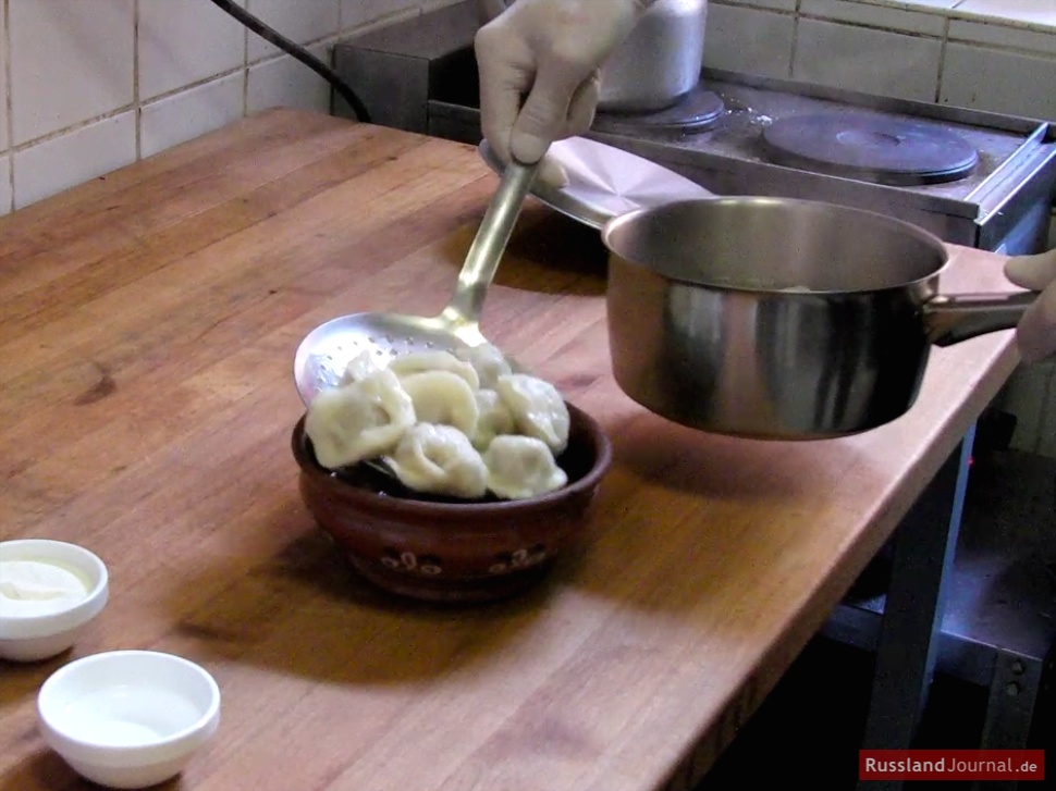 Sibirische Pelmeni in Schüssel geben