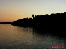 Dunkler Wald mit Lenin-Denkmal am Fluss in Russland 