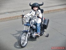 Kleiner Junge mit Helm auf Motorrad