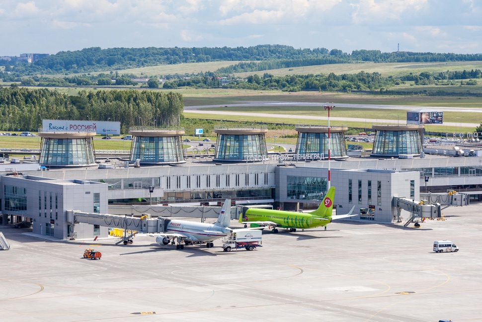 Renoviertes Flughafengebäude mit fünf Türmen und zwei Flugzeuge davor