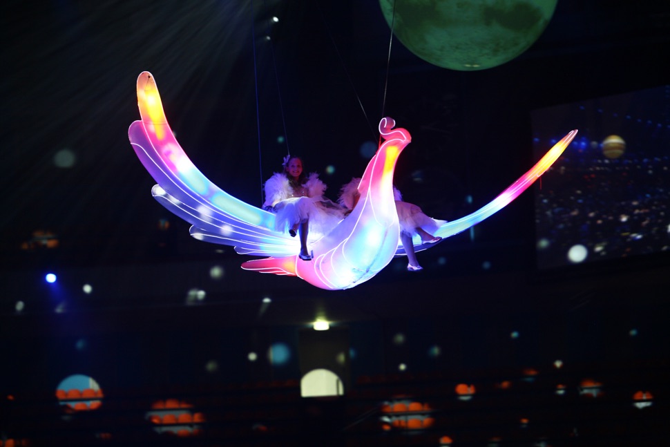 Zwei Mädchen fliegen auf dem Rücken eines beleuchteten Feuervogels
