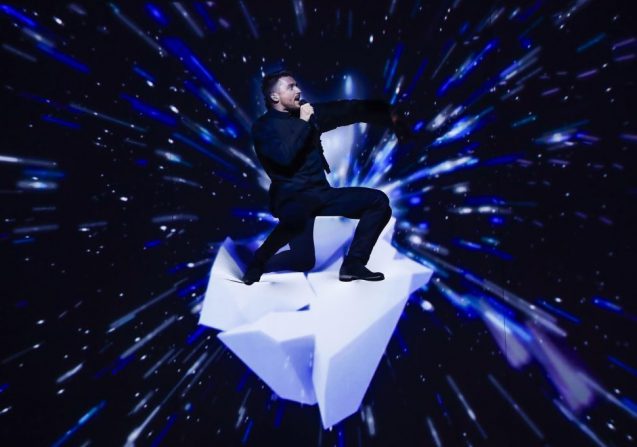 Sergey Lazarev im dunklen Anzug singt kniend auf einem Knie
