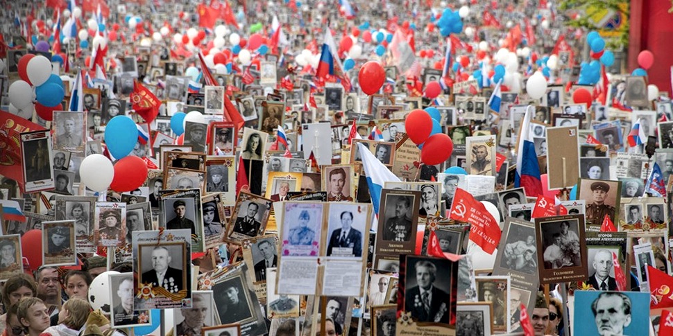 Menschen mit Portraits und weißen, roten und blauen Luftballons