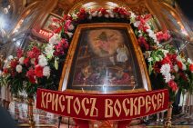 Osterblumen um eine Ikone und die Schrift auf Russisch "Christus ist auferstanden".